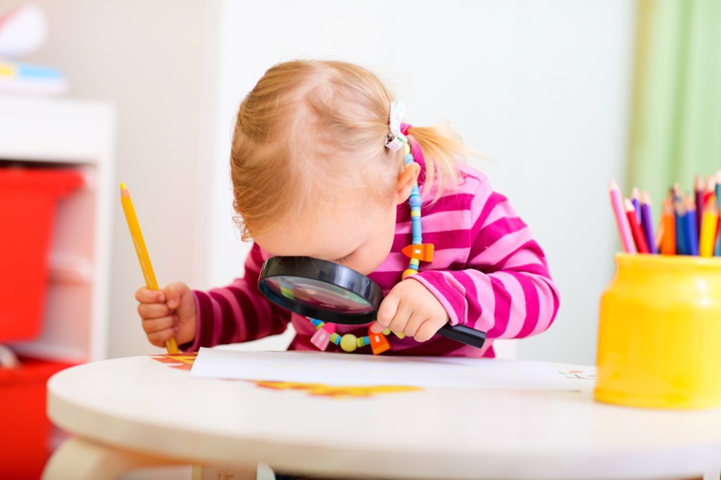 Curious girl with a magnifying glass.